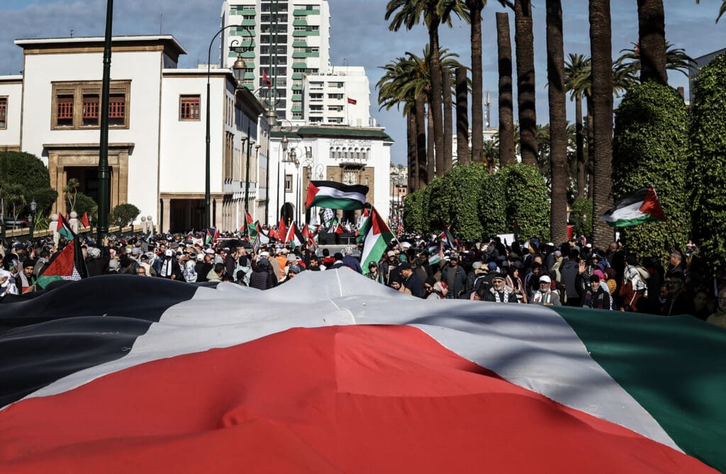 Protesters lift a giant flag of Palestine during a demonstration in Rabat on February 11, 2024, in solidarity with Palestinians amid Israel's ongoing bombardment of the Gaza Strip as the war with the militant Hamas group continues. (Photo by FADEL SENNA / AFP)