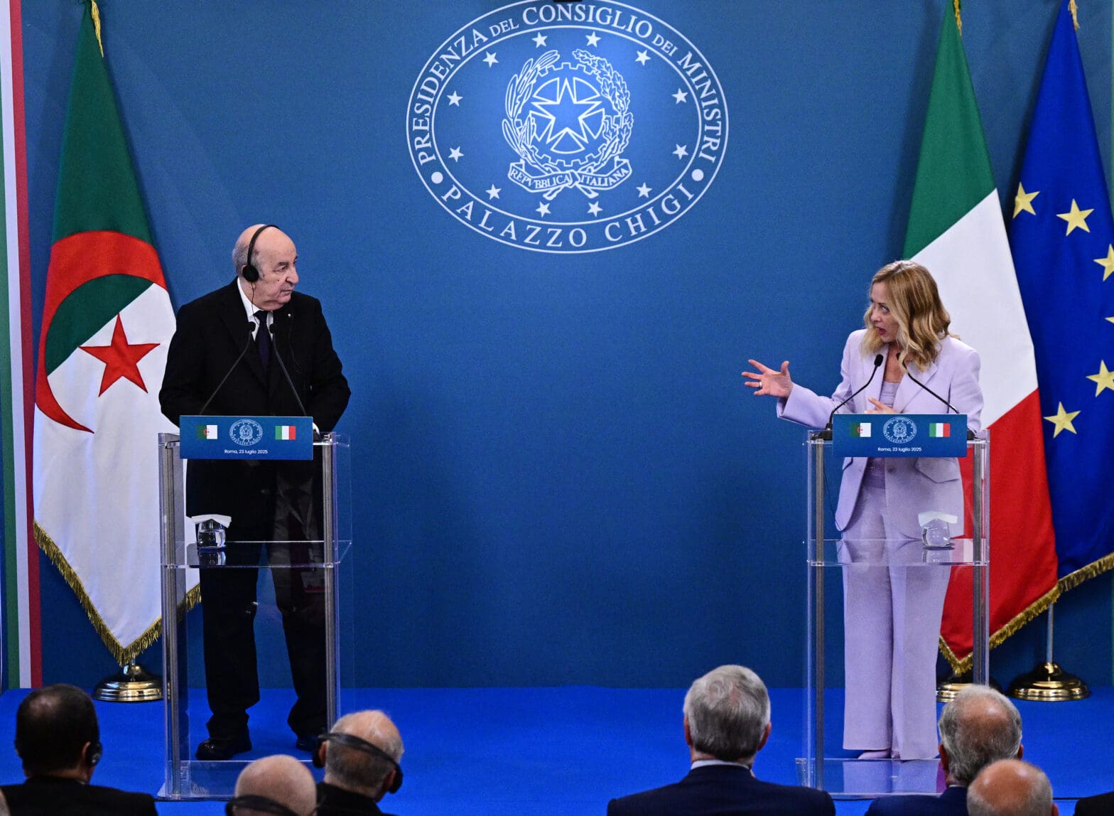 Algerian President Abdelmadjid Tebboune shakes hands with Italian Prime Minister Giorgia Meloni in Rome on July 24, 2025, with Algerian and Italian flags in the background during a state visit.